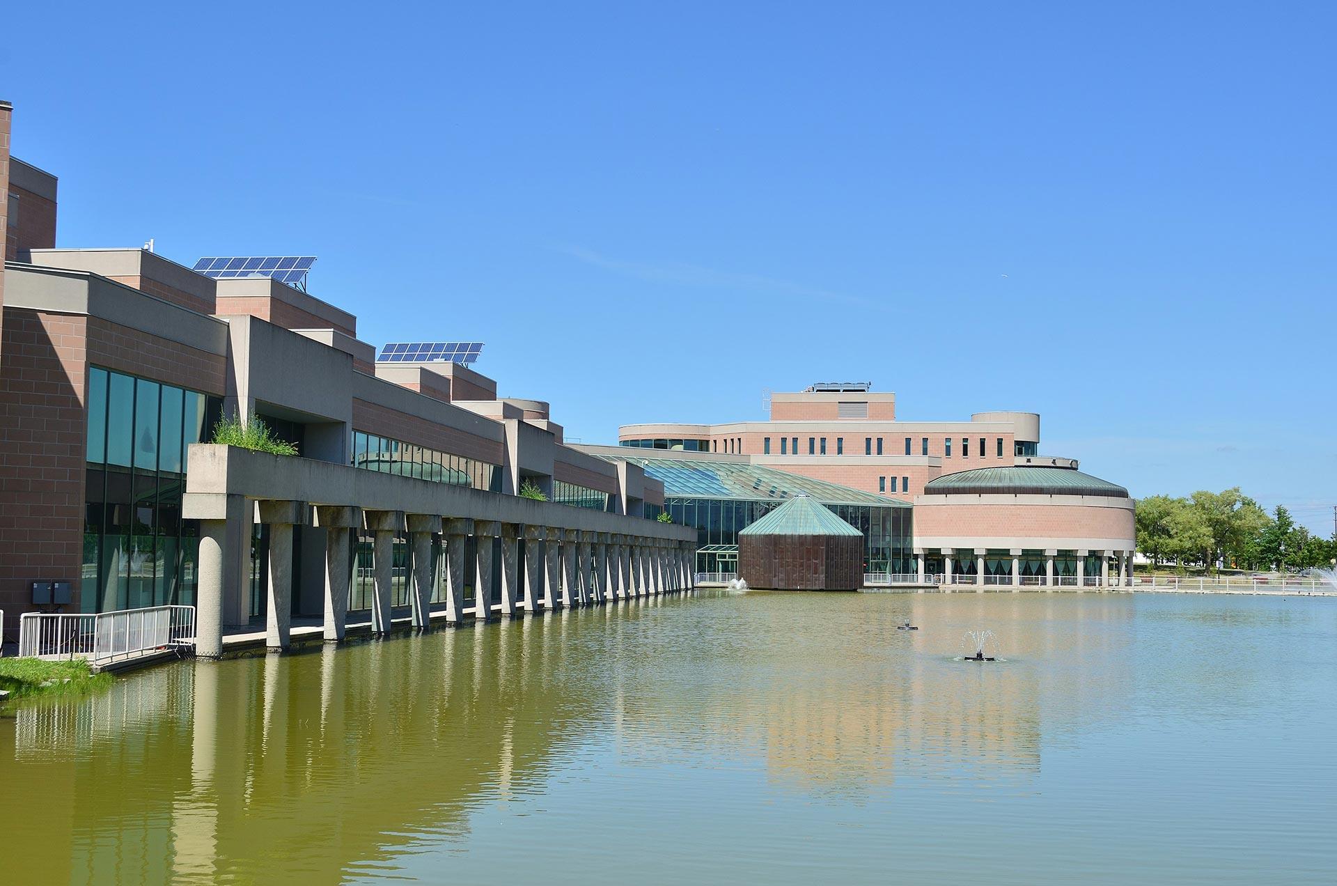 Exterior photo of an office building next to a pond